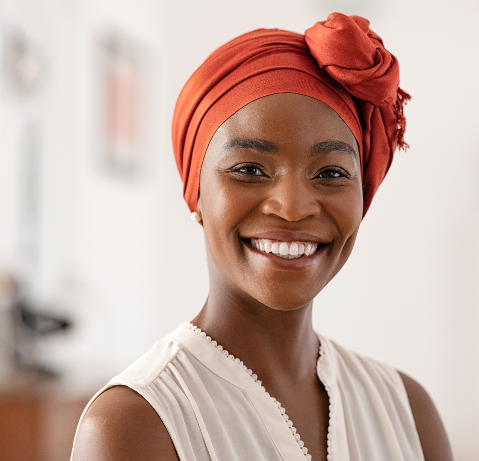 Portrait of a smiling woman in an orange head wrap